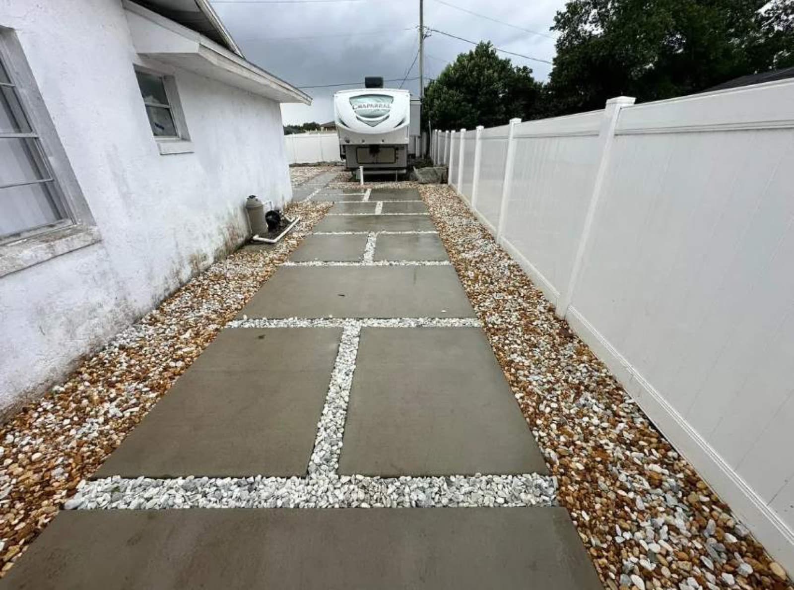 Finished concrete pads with white-gravel infill and RV driveway in Central Florida — Firsthand Lawn and Landscape